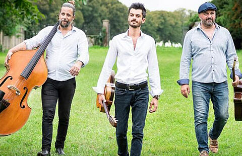 Photo des trois musiciens dans un champs en train de marcher
